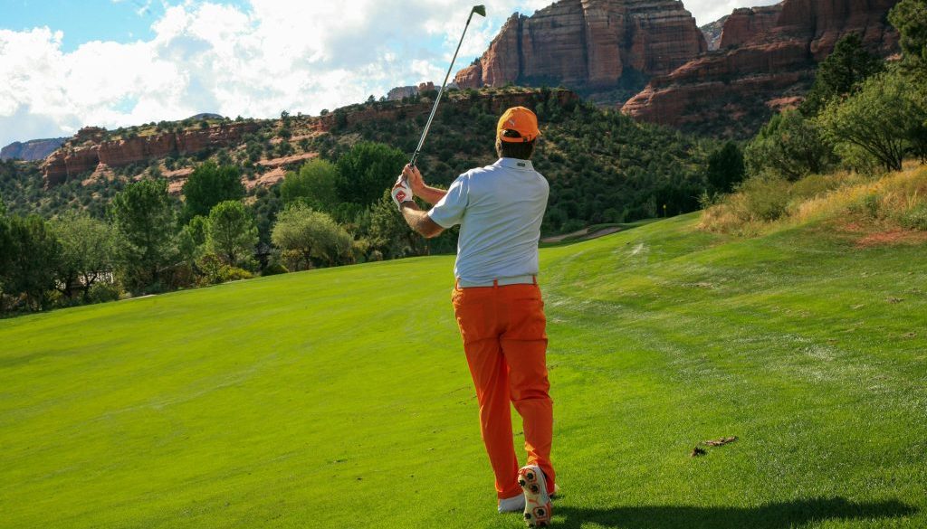 Golf Spieler schlägt Eisen vom Rough